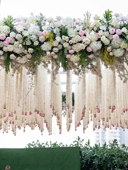 A detail shot of the intricate floral work, featuring thousands of tuberose strings and fresh roses that create a delicate, fragrant curtain effect under the main canopy.