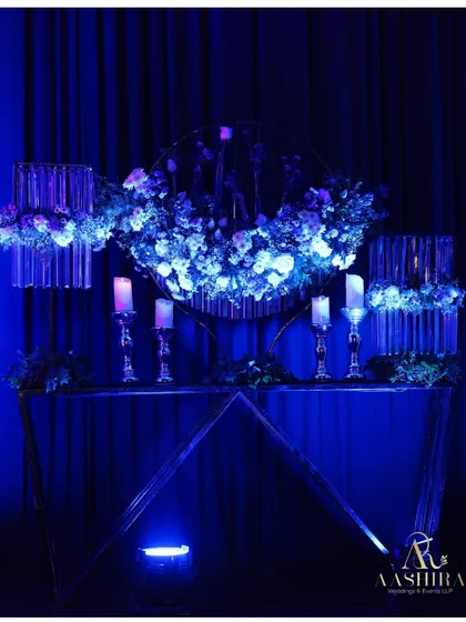 A modern art installation where florals were placed in hanging test tubes and illuminated by blue light, creating a sense of floral poetry.