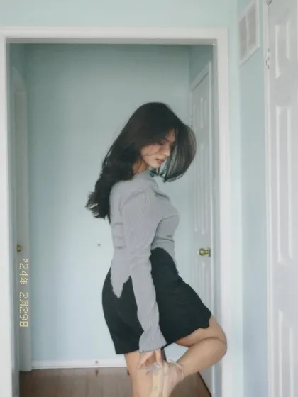 An artistic, blurry shot of the grey top and black skirt outfit.