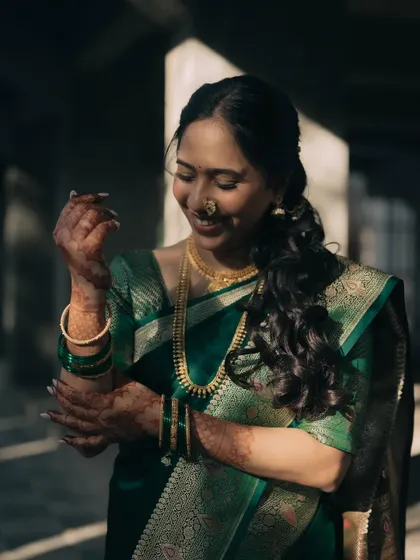 This shot focuses on the bride's soft, wavy braided hairstyle, which adds a touch of modern romance to her traditional green saree look.