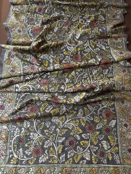 This is a full view of our authentic Srikalahasti Kalamkari art on a charcoal grey silk drape. Every intricate floral vine is hand-painted using traditional techniques and natural vegetable dyes, making each dupatta a unique piece of art.