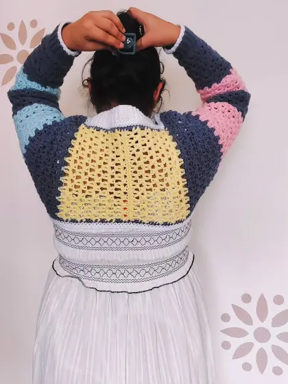 The back view of the Gaea Shrug, a unique piece that combines a shrug with a choker collar. The color-blocked design makes it a true statement piece.