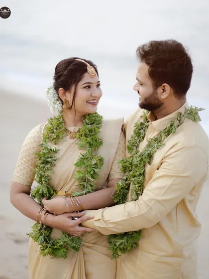 A happy, candid moment between a couple on the beach, sharing a smile. The natural light and relaxed pose make this pre-wedding photo feel authentic and joyful.