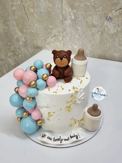 "We can bearly wait" is such a popular baby shower theme. This design features a cascade of pink and blue chocolate spheres, a fondant teddy, and milk bottles.