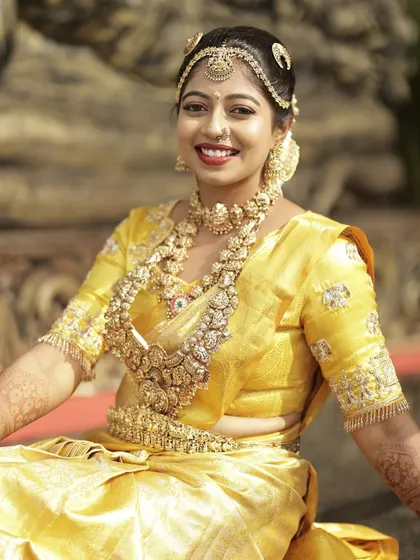 A joyful close-up of the bride, her smile as bright as her beautiful yellow wedding saree and custom blouse.