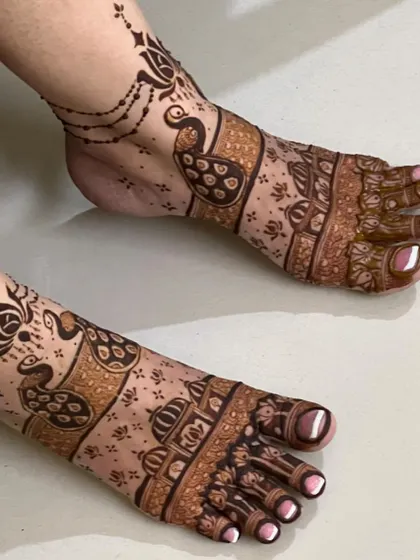 A modern take on bridal foot mehendi, with peacock and dome motifs creating a stylish and unique pattern.