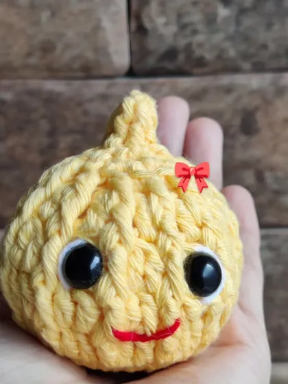 A close-up of the adorable, hand-stitched face of the Modak.