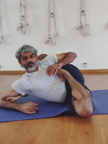 A variation of Eka Pada Sirsasana (One Leg Behind the Head Pose) while lying down. Finding ease in such a complex posture comes only after many days of consistent and dedicated effort.