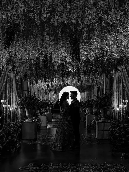 In the quiet moments between celebrations, we find the most profound romance. This artistic silhouette, captured in black and white, uses light and shadow to create a dramatic and intimate portrait that feels like a scene from a classic film.
