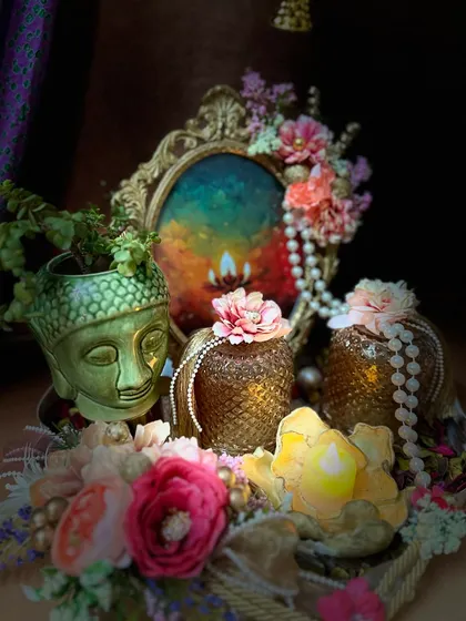 A beautifully lit, artistic shot of our Buddha planter hamper. The arrangement includes a vintage style frame, textured jars, and a lotus shaped candle, creating a serene and spiritual vibe.