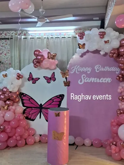 A pink butterfly themed birthday decoration for Samreen. The setup includes two backdrops, pink and chrome balloon arrangements, and butterfly cutouts.