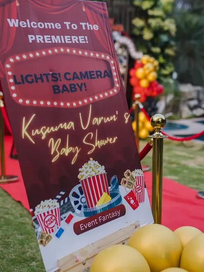 "Welcome to the Premiere!" This custom sign for the movie-themed baby shower immediately immerses guests in the fun 'Lights! Camera! Baby!' concept, complete with popcorn and film reel graphics.