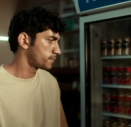A character from the Nescafé ad choosing his coffee. His simple, neutral-toned t-shirt keeps the focus on the product and his expression.