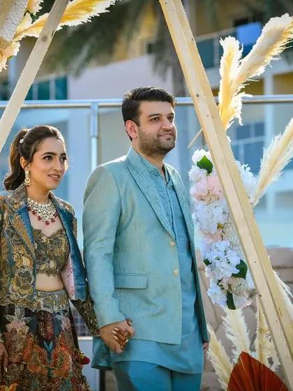 The couple makes their entrance at the Boho welcome lunch, their pastel outfits perfectly complementing the beachy, relaxed vibe.