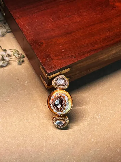 A close-up of a unique three-stone ring, featuring polki diamonds set in a delicate, artistic design.