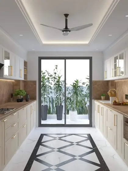 A bright and airy parallel kitchen design with off-white cabinets and gold handles. The space opens onto a balcony, flooding the room with natural light, and features a striking black and white geometric floor pattern.