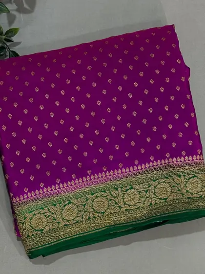 A vibrant purple Banarasi crepe saree with a contrasting green and gold border.