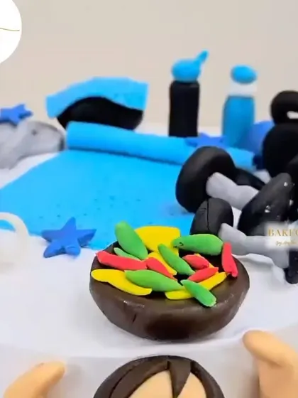 A close-up of the gym-themed cake, showing the tiny fondant details like the kettlebells and the healthy salad bowl.