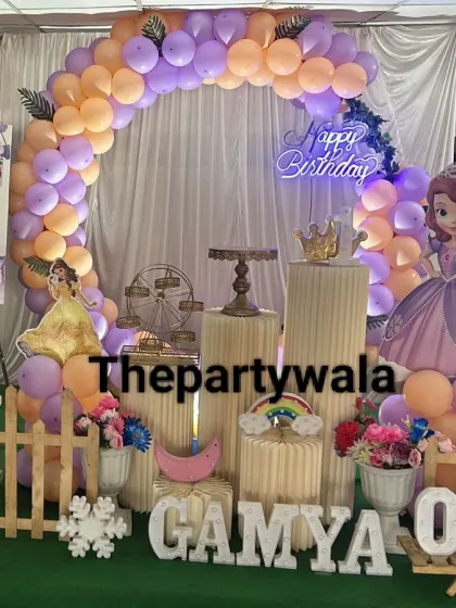 A Sofia the First theme with a peach and purple balloon arch, complete with a personalized photo board.