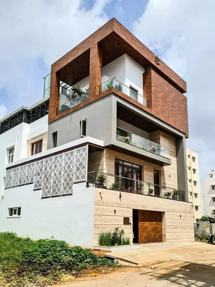 This is a completed villa project, a duplicate of the one in the featured section. It showcases my ability to execute complex material combinations, including natural stone, wood cladding, and jalli screens, in a real-world setting.