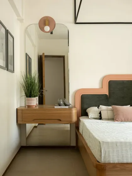 A detail of a dressing table area in Kolam Pop, with a custom mirror and a floating wooden console, blending functionality with the home's whimsical aesthetic.