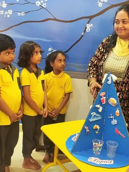 A teacher uses a model to explain the different states of matter: solid, liquid, and gas. Interactive lessons like this make abstract science concepts concrete and understandable for young learners.