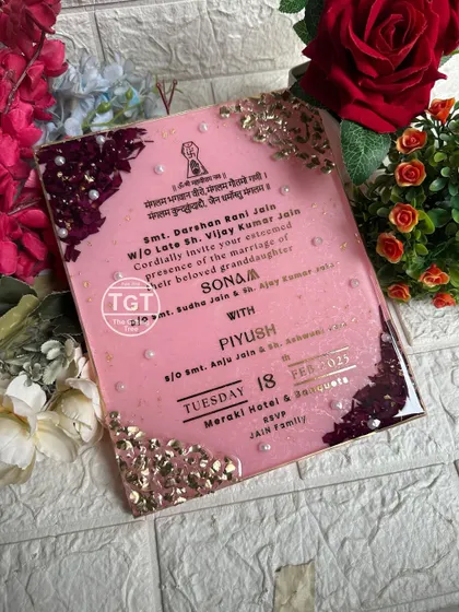 An angled view showing the glossy finish and the texture of the preserved petals and stones. This is an invitation that doubles as a piece of art.