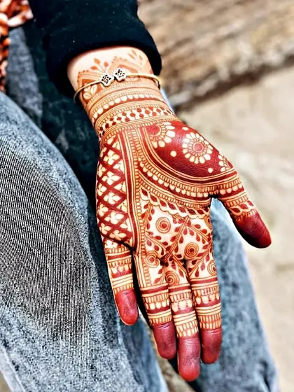 A beautiful fresh mehndi stain, just a few hours after removing the paste. The color is a vibrant reddish-orange and will continue to darken. The design features a mix of jaali and floral patterns.