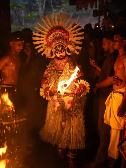 A series showing the Karim Gullikan Theyyam performance, surrounded by devotees and fire. These images document the energy of the crowd and the deity's commanding presence during the ritual.