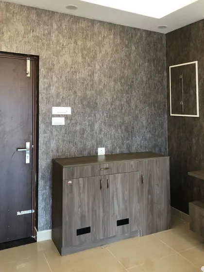 A dark, textured wallpaper that mimics the look of raw silk or concrete, adding an industrial and sophisticated feel to the room.