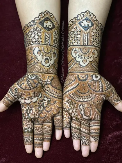 A beautiful example of Indian mehendi design. The hands are covered in a mix of floral, geometric, and elephant motifs, creating a rich and balanced composition.