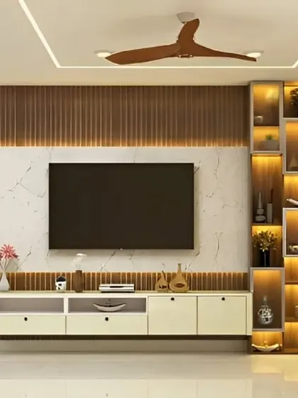 A beautiful living room setup where the TV unit is flanked by a tall, illuminated display cabinet. The combination of marble, wood, and light creates a luxurious feel.