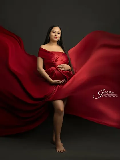 This portrait showcases the beauty of simplicity and movement. A single piece of vibrant red fabric is expertly draped and tossed to create a dynamic and artistic effect.