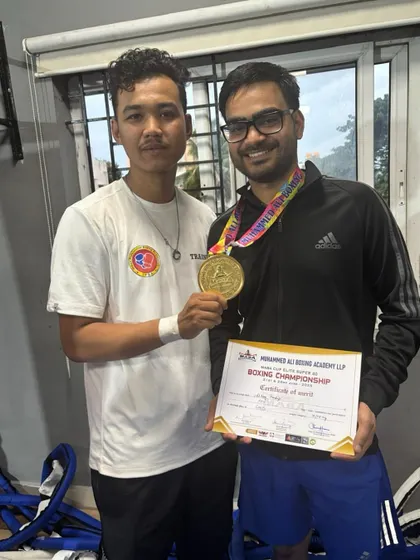 A coach and his fighter. Posing with the gold medal and certificate after a successful championship. This is the partnership that leads to victory.