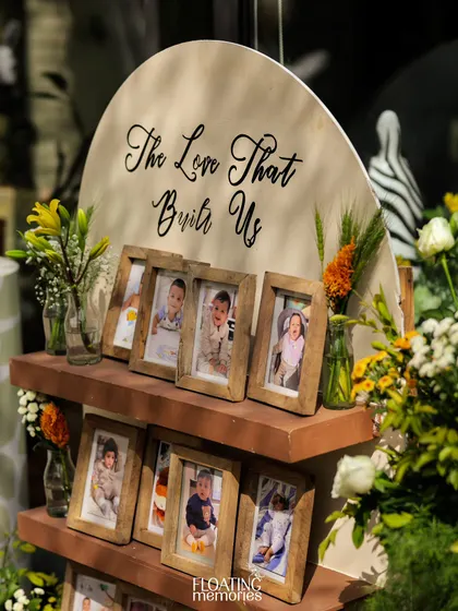 A closer look at the photo memory shelf, adorned with fresh flowers and surrounded by safari-themed decor.