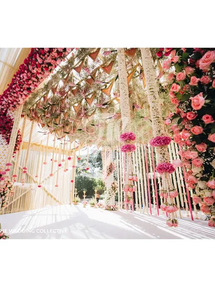 A detailed view of the mandap, where hanging floral strings and ombre rose arrangements create a stunning backdrop. The intricate work and sheer volume of flowers demonstrate our expertise in floral design for traditional Indian weddings.