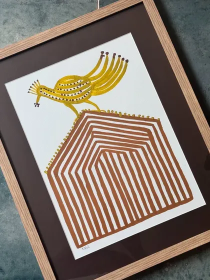 This framed Bhil art piece, featuring a bird on a mound, uses natural dyes to create its earthy tones. It's part of our curated collection that honours traditional Indian folk art and supports the artisans who create it.