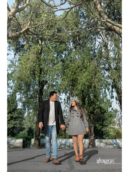 A stylish walk down a beautiful, tree-lined avenue. The couple's coordinated outfits and confident stride make for a chic and modern candid shot.