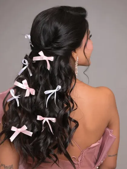A side view of the bow-adorned hairstyle, showing how the accessories are scattered through the lengths of the hair for a dreamy effect.