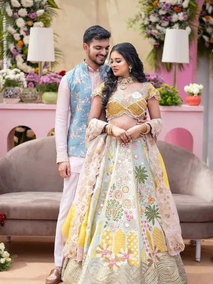 The groom admires his bride in a setting filled with pastel flowers and modern decor. The scene is a perfect example of how I blend contemporary style with timeless romance for engagement ceremonies.