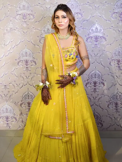 Embracing tradition with intricate Mehendi art. The makeup is kept fresh and glowing to complement the beautiful henna and floral jewelry.