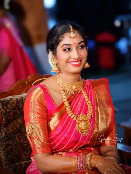 Simple yet stunning. This look features a touch of glitter on the eyes and a bright lip, adding a touch of modern glam to a traditional bridal appearance.