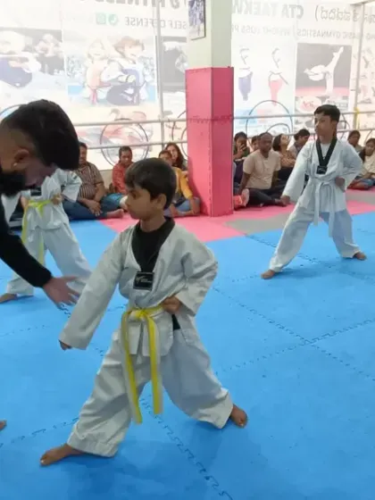 I provide a hands-on correction to a young student to ensure his stance is perfect.