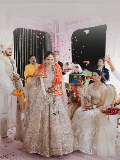 A candid moment from the wedding ceremony, filled with smiles and a shower of rose petals.