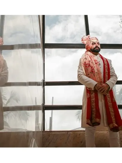 A classic portrait of the groom, his reflection in the glass adding a layer of depth and sophistication.