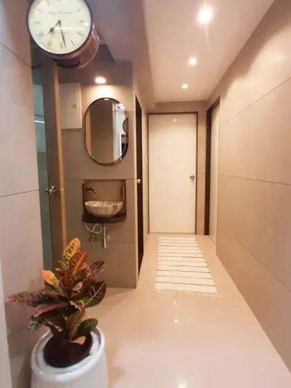Passageways are often overlooked, but I see them as opportunities to add character. This entryway was beautified with soft wall paneling, recessed ceiling lights, and a stylish washbasin, turning a simple corridor into a feature of the home.