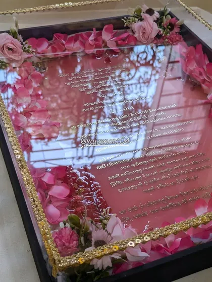 The reflection in this photo of the pink wedding Kankotri shows off its incredibly glossy, mirror-like finish.