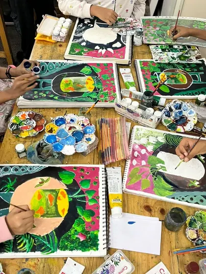 A group of students works on a Fauvism-inspired project, using bold, non-naturalistic colors to paint fishbowls. This exercise encourages creativity and a departure from traditional representation.