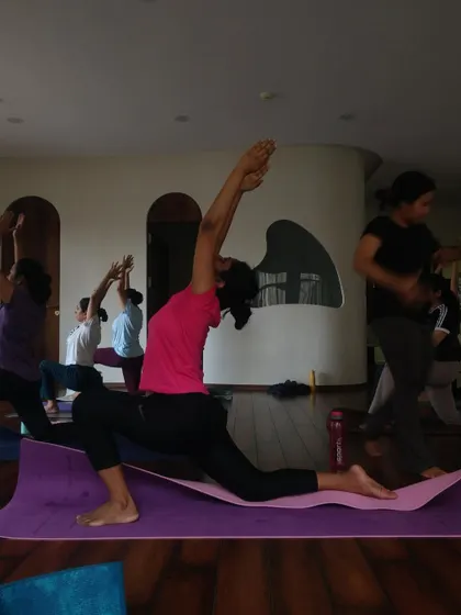 A student reaches for the sky in Anjaneyasana (Low Lunge), a beautiful heart and hip opener.