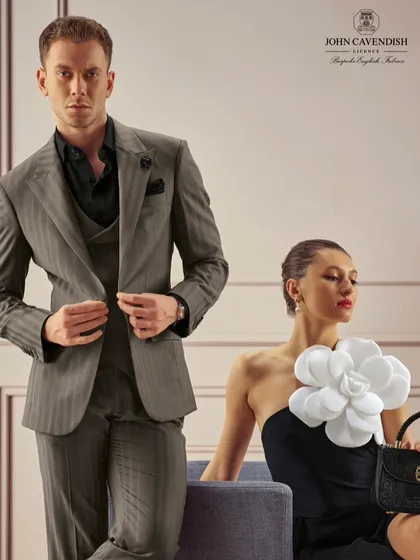 Another look from a bespoke menswear campaign. The female model's makeup is clean and sculptural, with a sleek bun and defined features that speak of understated luxury.
